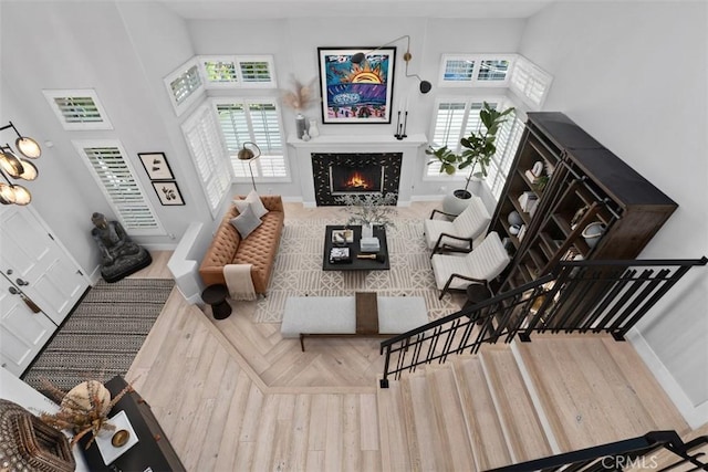 12 Argos, Laguna Niguel, CA 92677 - living room with wood finished floors, plenty of natural light, a warm lit fireplace, stairway, and a towering ceiling