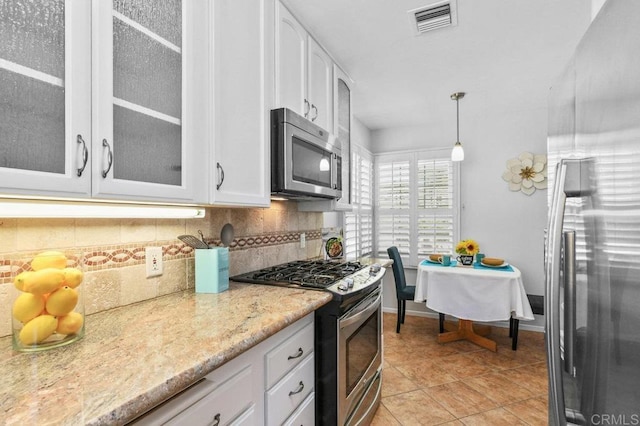 4719 Constance Dr, San Diego, CA 92115 - kitchen with appliances with stainless steel finishes, decorative backsplash, glass insert cabinets, and white cabinets