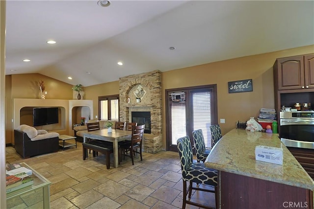 22331 Walnut St, Wildomar, CA 92595 - dining space with lofted ceiling, stone tile flooring, recessed lighting, and a stone fireplace