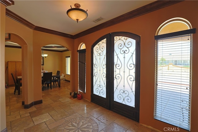 22331 Walnut St, Wildomar, CA 92595 - foyer featuring arched walkways, french doors, ornamental molding, stone tile floors, and baseboards
