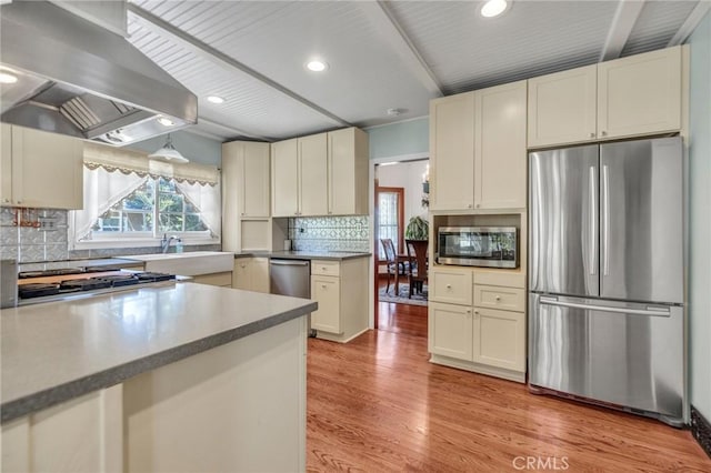 8213 Ocean View Ave, Whittier, CA 90602 - kitchen featuring stainless steel appliances, wall chimney range hood, light wood-style flooring, tasteful backsplash, and recessed lighting