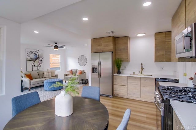 5610 Streamview Dr, San Diego, CA 92105 - kitchen featuring appliances with stainless steel finishes, a sink, light countertops, recessed lighting, and light wood-style floors