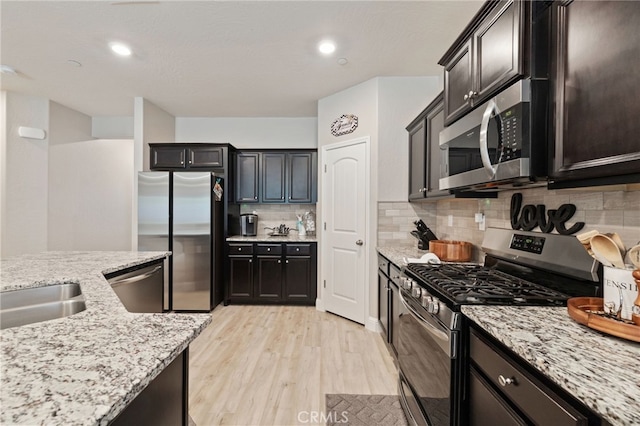 748 Expedition Way W, Madera, CA 93636 - kitchen featuring stainless steel appliances, light wood-style floors, light stone countertops, backsplash, and recessed lighting
