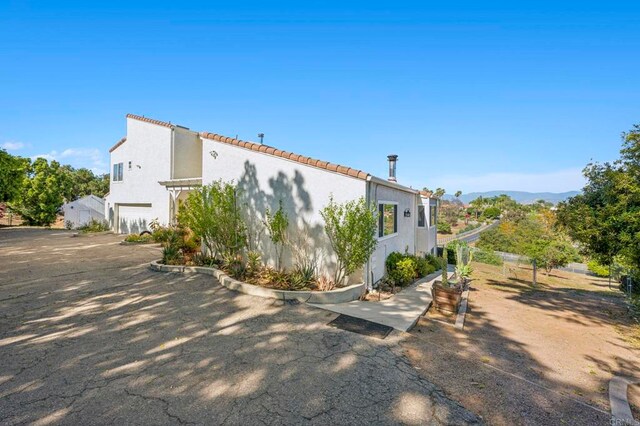 3016 Alta Vista Dr, Fallbrook, CA 92028 - view of property exterior featuring an attached garage, stucco siding, and a tile roof