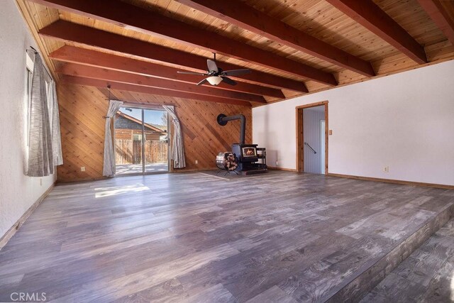 817 E Mountain View Blvd, Big Bear City, CA 92314 - unfurnished room with a wood stove, wood finished floors, wood walls, a ceiling fan, and baseboards