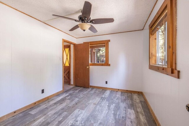 817 E Mountain View Blvd, Big Bear City, CA 92314 - unfurnished room with wood finished floors, baseboards, a ceiling fan, and a textured ceiling