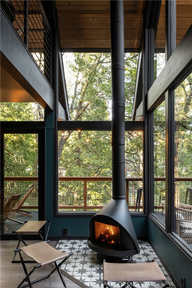 607 Old Toll Rd, Lake Arrowhead, CA 92352 - sunroom with a wood stove and healthy amount of natural light