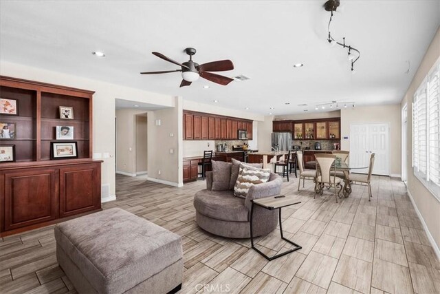 27109 Woodglen Ln, Moreno Valley, CA 92555 - living area with a ceiling fan, baseboards, recessed lighting, rail lighting, and light wood-style flooring