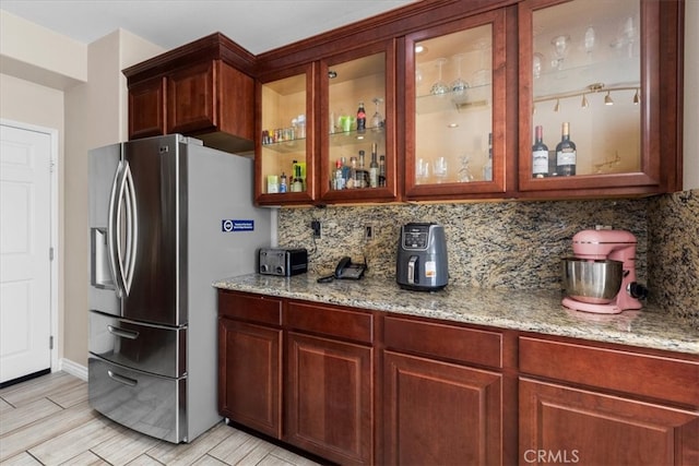 27109 Woodglen Ln, Moreno Valley, CA 92555 - kitchen with stainless steel fridge with ice dispenser, tasteful backsplash, light stone countertops, and glass insert cabinets