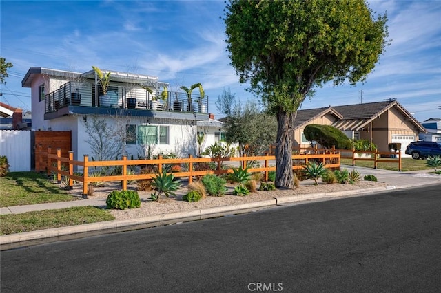 16782 Heritage Ln, Huntington Beach, CA 92647 - view of front facade with a balcony, a fenced front yard, and a garage