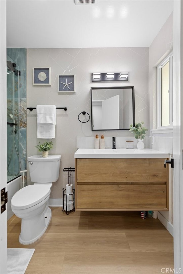 16782 Heritage Ln, Huntington Beach, CA 92647 - bathroom with vanity, toilet, wood finished floors, and combined bath / shower with glass door