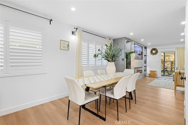16782 Heritage Ln, Huntington Beach, CA 92647 - dining room featuring plenty of natural light, light wood-type flooring, recessed lighting, baseboards, and a large fireplace
