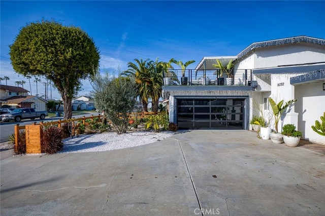 16782 Heritage Ln, Huntington Beach, CA 92647 - view of home's exterior with concrete driveway, a balcony, stucco siding, and a garage