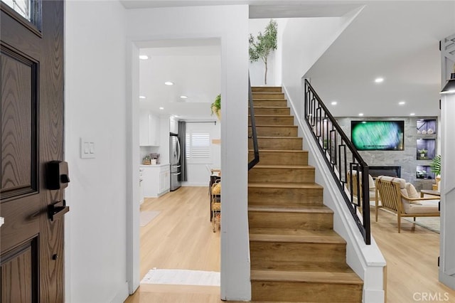 16782 Heritage Ln, Huntington Beach, CA 92647 - stairs featuring wood finished floors, recessed lighting, a fireplace, and baseboards