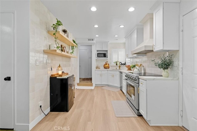 16782 Heritage Ln, Huntington Beach, CA 92647 - kitchen featuring stainless steel appliances, wall chimney exhaust hood, white cabinetry, and recessed lighting