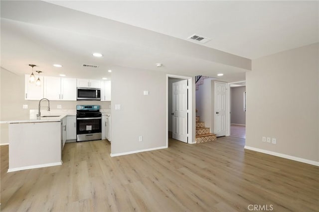 43334 32nd St W Unit 12, Lancaster, CA 93536 - unfurnished living room featuring a sink, stairway, baseboards, light wood-style floors, and recessed lighting