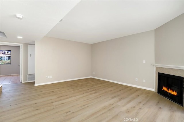 43334 32nd St W Unit 12, Lancaster, CA 93536 - unfurnished living room featuring a fireplace, light wood finished floors, and baseboards