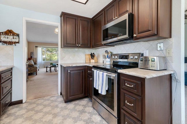 1064 Glen Arbor Dr, Encinitas, CA 92024 - kitchen featuring stainless steel appliances, dark brown cabinetry, decorative backsplash, and light colored carpet