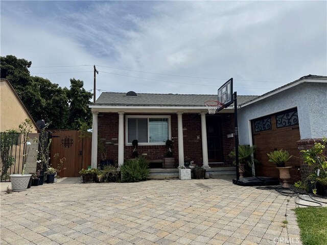 4552 Los Toros Ave, Pico Rivera, CA 90660 - view of front facade featuring brick siding, a gate, covered porch, and a garage