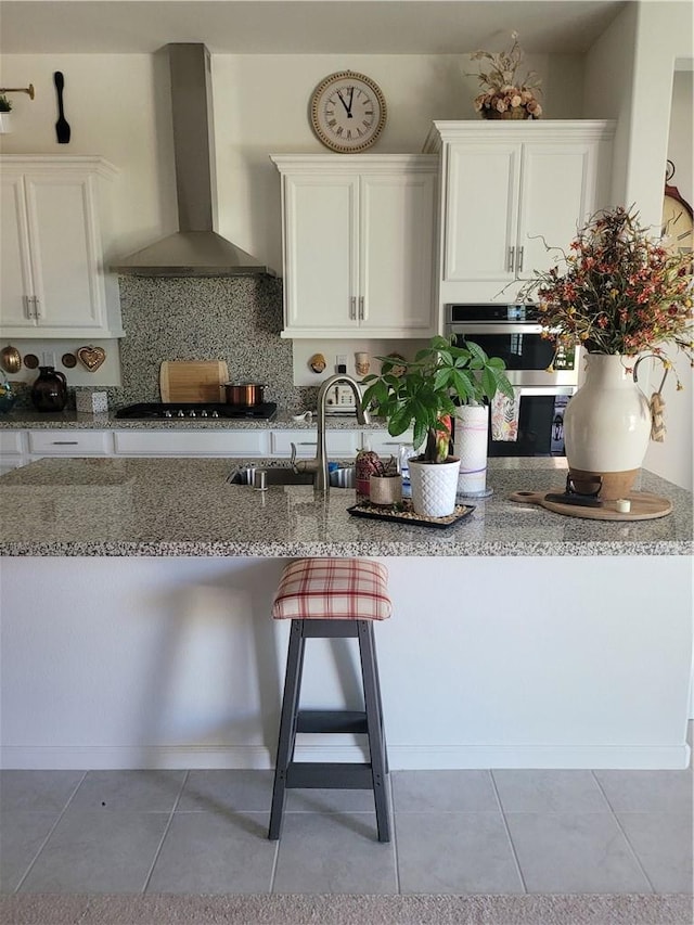 11915 Sagecrest Ct, Corona, CA 92883 - kitchen featuring wall chimney exhaust hood, light stone counters, gas stovetop, white cabinets, and a sink