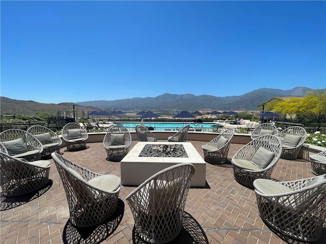 11915 Sagecrest Ct, Corona, CA 92883 - view of patio / terrace featuring an outdoor fire pit, a mountain view, and a community pool