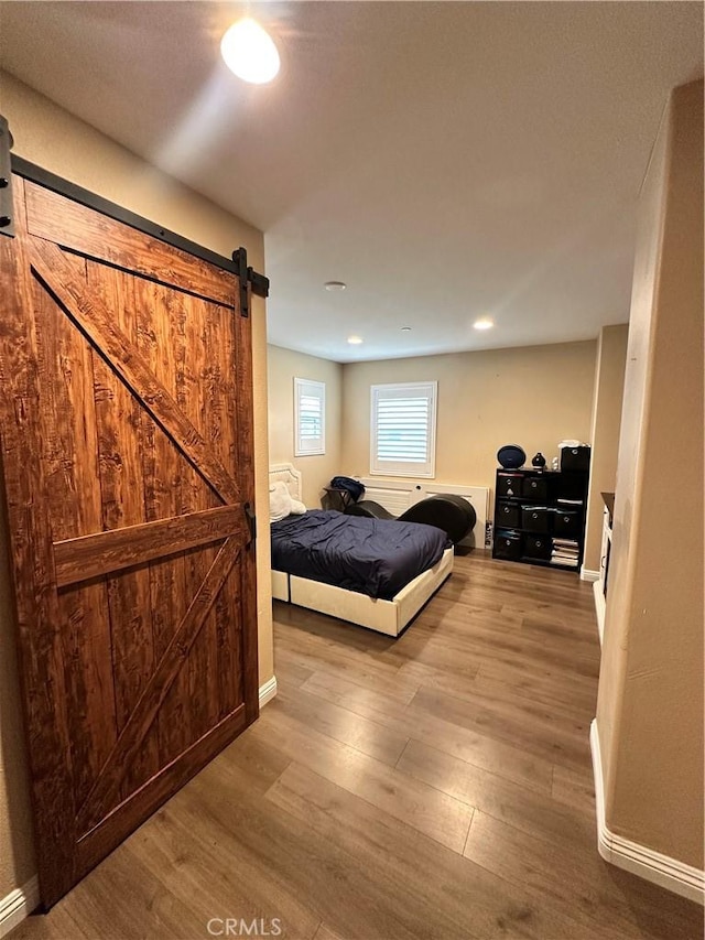 36569 Olea Ct, Beaumont, CA 92223 - bedroom with a barn door, wood finished floors, baseboards, and recessed lighting