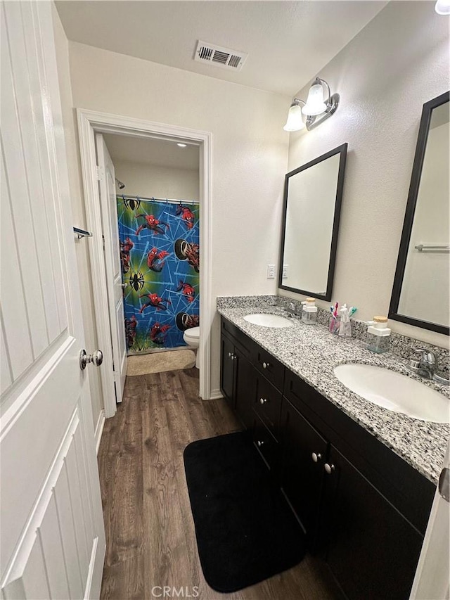 36569 Olea Ct, Beaumont, CA 92223 - full bathroom with double vanity, toilet, wood finished floors, and a shower with shower curtain