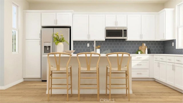 2557 E Hyde Paseo, Ontario, CA 91762 - kitchen featuring stainless steel microwave, fridge with ice dispenser, white cabinets, decorative backsplash, and light wood-style floors