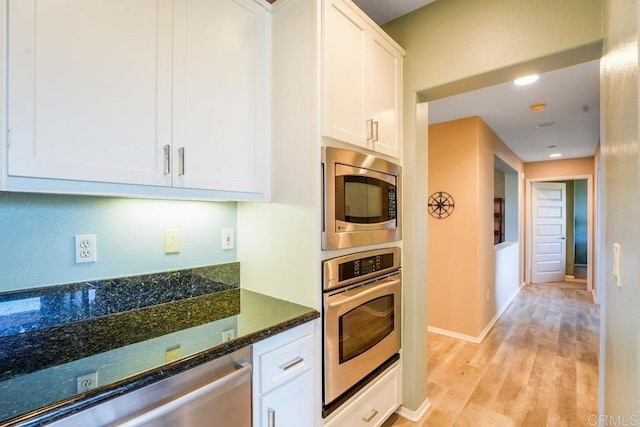 4021 Canario St Unit 235, Carlsbad, CA 92008 - kitchen featuring appliances with stainless steel finishes, white cabinets, light wood-style floors, dark stone counters, and recessed lighting