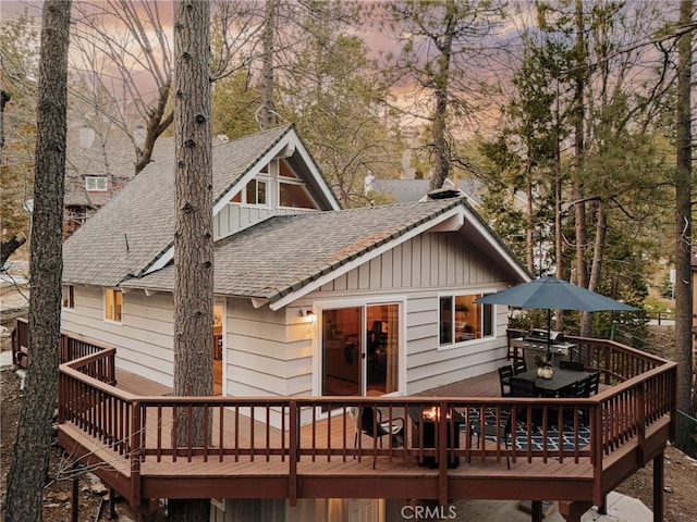 26625 Pinehurst Dr, Lake Arrowhead, CA 92352 - back of property with a deck, a shingled roof, board and batten siding, and outdoor dining space