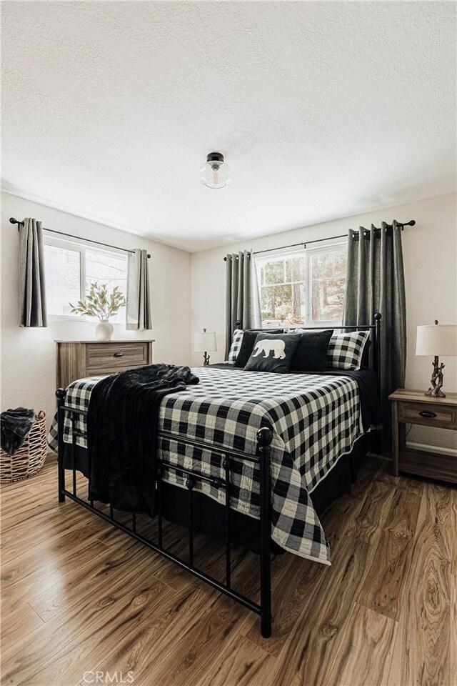 26625 Pinehurst Dr, Lake Arrowhead, CA 92352 - bedroom featuring wood finished floors and a textured ceiling