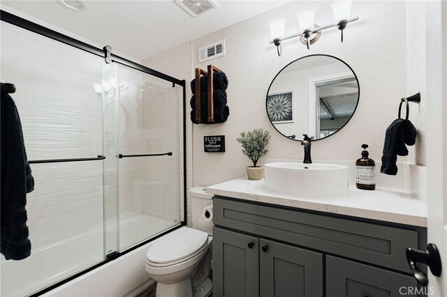 26625 Pinehurst Dr, Lake Arrowhead, CA 92352 - bathroom with vanity, toilet, combined bath / shower with glass door, and a textured wall