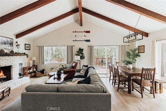 26625 Pinehurst Dr, Lake Arrowhead, CA 92352 - living area with healthy amount of natural light, light wood finished floors, a brick fireplace, high vaulted ceiling, and wood ceiling with exposed beams