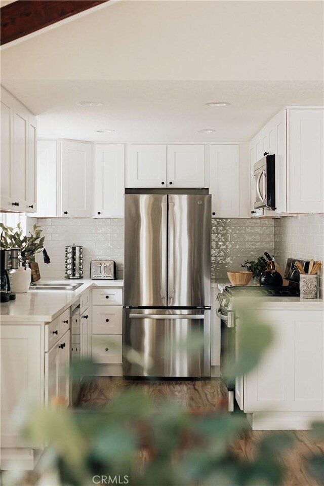 26625 Pinehurst Dr, Lake Arrowhead, CA 92352 - kitchen with appliances with stainless steel finishes, decorative backsplash, light countertops, and white cabinetry