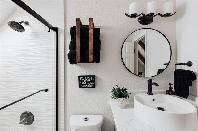 26625 Pinehurst Dr, Lake Arrowhead, CA 92352 - full bath with a sink, a shower with shower door, a textured wall, and toilet