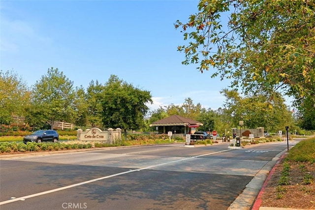 23442 Via Codorniz, Coto De Caza, CA 92679 - view of asphalt road with curbs, traffic signs, and a gated entry