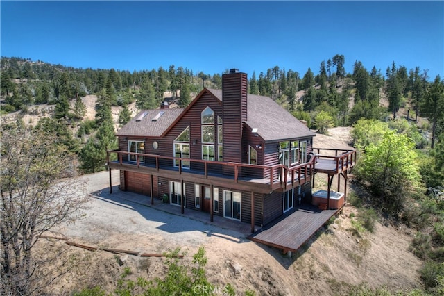 175 N Trails End Rd, Green Valley Lake, CA 92341 - back of property featuring a chimney, driveway, a shingled roof, and a deck