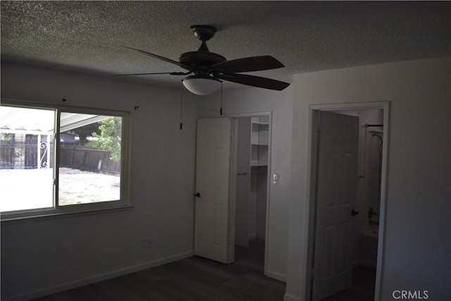 815 California Ave, Dos Palos, CA 93620 - unfurnished bedroom with dark wood-type flooring, a textured ceiling, baseboards, and ceiling fan