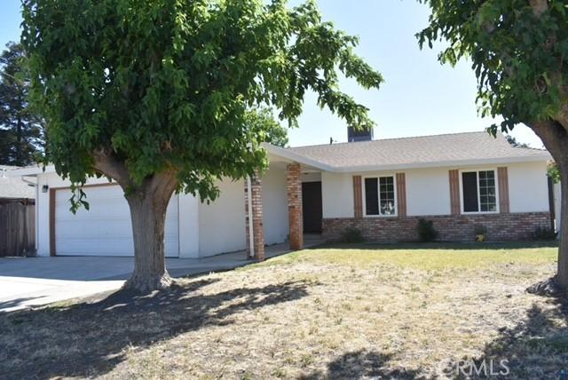 815 California Ave, Dos Palos, CA 93620 - ranch-style house with concrete driveway, an attached garage, brick siding, and stucco siding