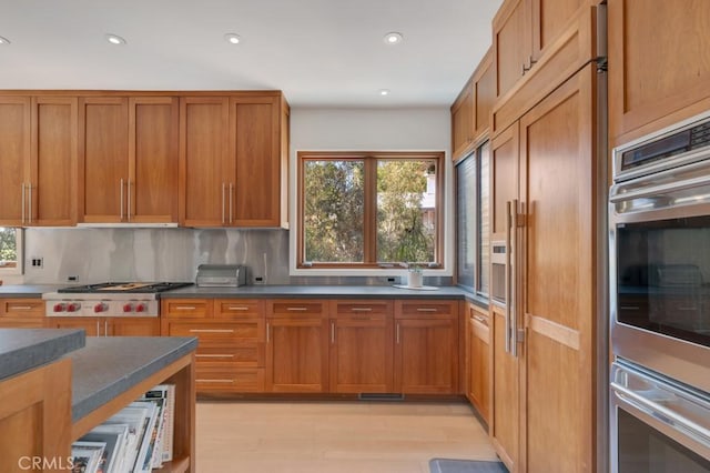 4315 Morro Dr, Woodland Hills, CA 91364 - kitchen featuring appliances with stainless steel finishes, healthy amount of natural light, light wood-type flooring, brown cabinets, and recessed lighting