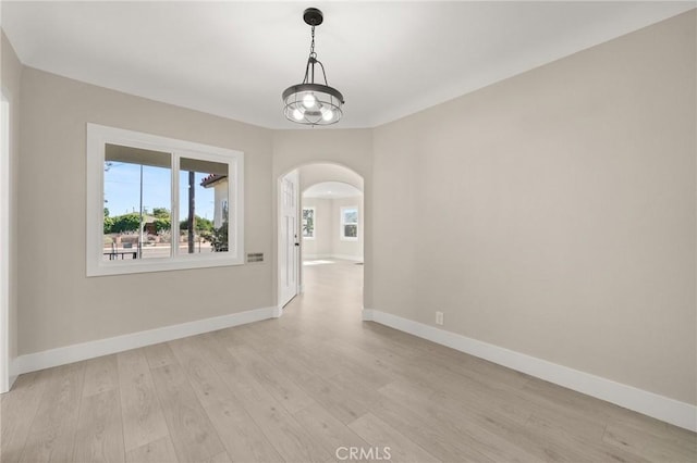 709 E 9th St, Pomona, CA 91766 - empty room with arched walkways, baseboards, and light wood-style floors