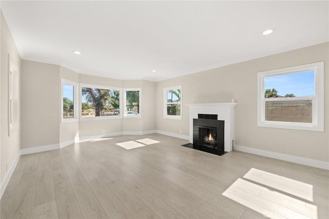 709 E 9th St, Pomona, CA 91766 - unfurnished living room featuring baseboards, a fireplace, light wood-style flooring, and recessed lighting