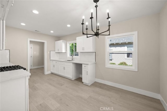 709 E 9th St, Pomona, CA 91766 - kitchen with a chandelier, a sink, light wood-style floors, baseboards, and recessed lighting
