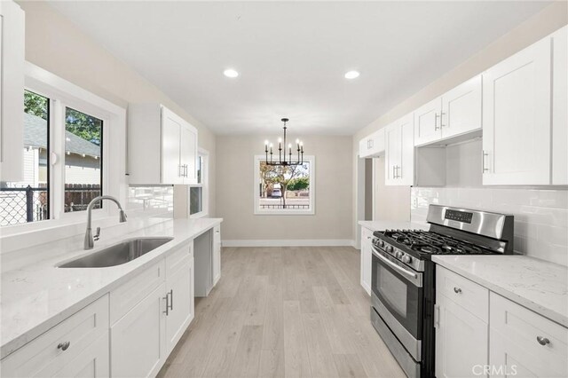 709 E 9th St, Pomona, CA 91766 - kitchen featuring stainless steel gas range, a sink, baseboards, plenty of natural light, and recessed lighting