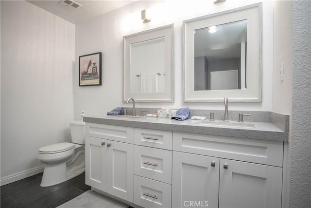 54229 Oakhill Ln, Quinta, CA 92253 - bathroom featuring double vanity, toilet, baseboards, and wood finished floors