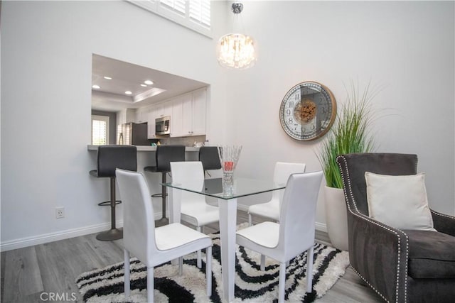 54229 Oakhill Ln, Quinta, CA 92253 - dining area featuring wood finished floors, a chandelier, recessed lighting, baseboards, and a tray ceiling