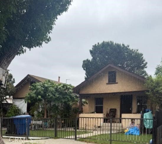 3805 Paloma St, Los Angeles, CA 90011 - bungalow-style home featuring a fenced front yard, a porch, and stucco siding