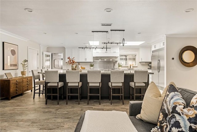 20402 Seven Seas Ln, Huntington Beach, CA 92646 - kitchen with built in refrigerator, white cabinetry, open floor plan, light wood-style floors, and ornamental molding