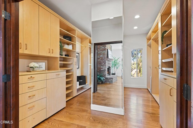13045 Ripple Creek Ln, Camarillo, CA 93012 - walk in closet with light wood-style flooring and a brick fireplace