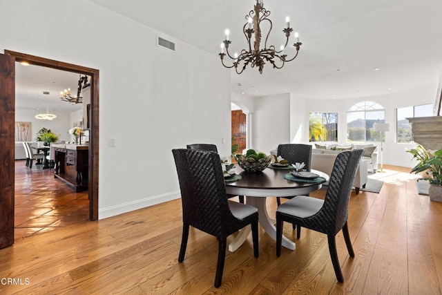 13045 Ripple Creek Ln, Camarillo, CA 93012 - dining area featuring a chandelier, light wood-type flooring, baseboards, arched walkways, and recessed lighting